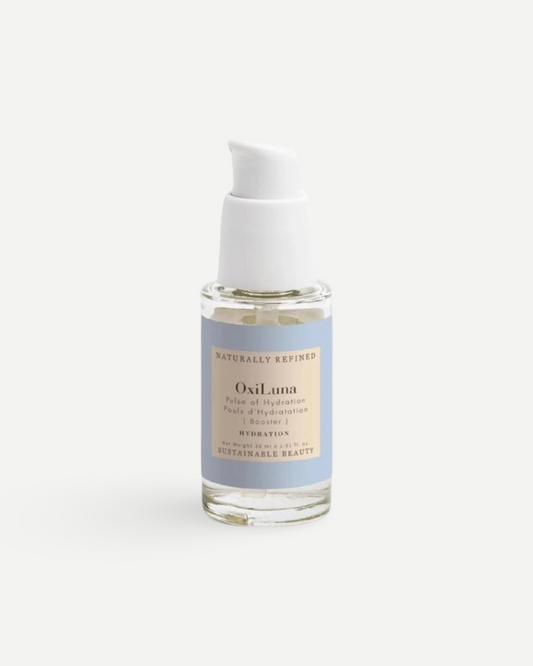 OxiLuna Pulse of Hydration Booster in sunlight, minimalist glass bottle glowing against textured concrete.